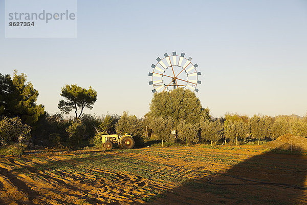 Spanien  Balearen  Mallorca  Windmühle und alter Traktor auf dem Feld