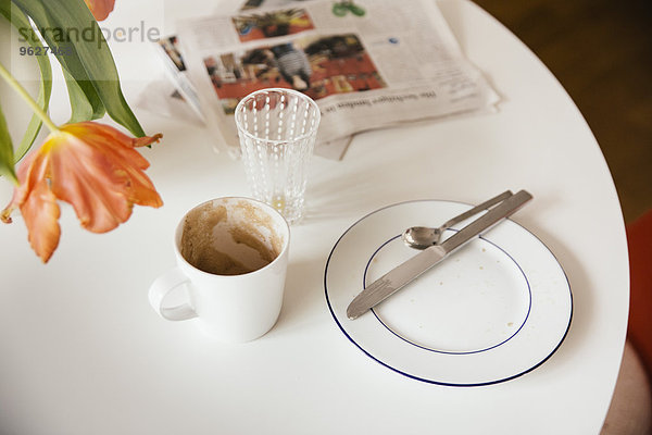 Frühstückstisch mit Zeitung nach Gebrauch