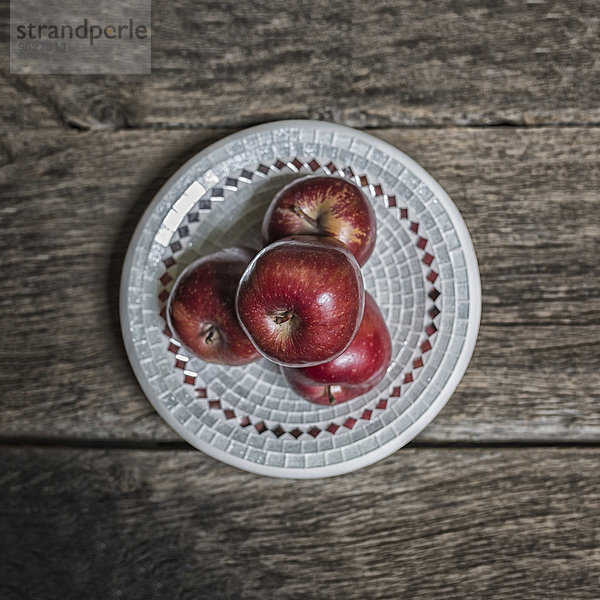 Vier rote Äpfel auf dem Teller