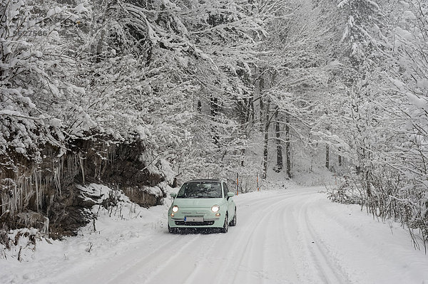 Deutschland  Bayern  Berchtesgadener Land  Auto auf Landstraße in Winterlandschaft