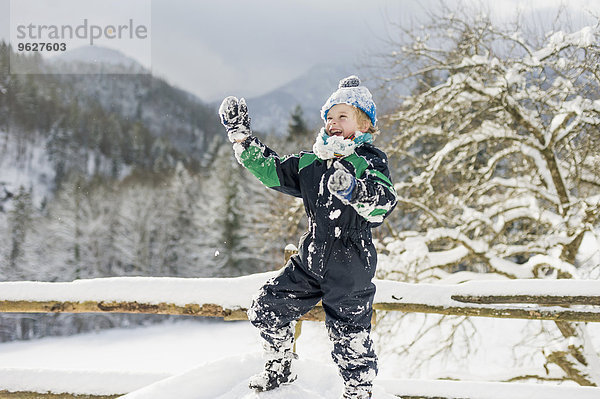 Deutschland  Bayern  Berchtesgadener Land  glücklicher Junge in Winterlandschaft