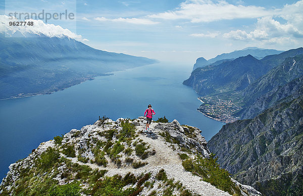 Italien  Trentino  Frau  die auf dem Berggipfel am Gardasee läuft