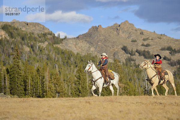 USA  Wyoming  zwei junge Cowboys beim Reiten