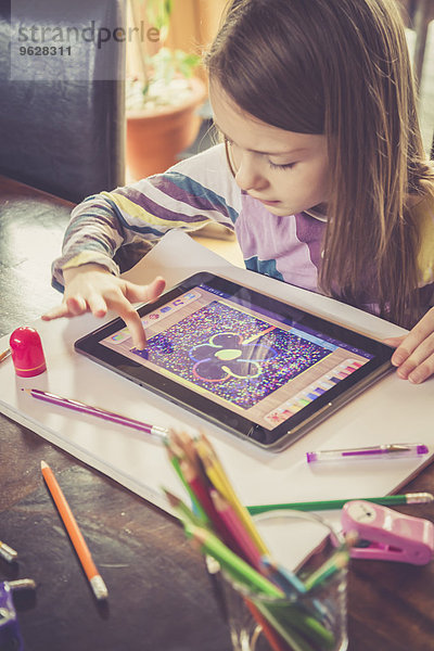 Kleines Mädchen mit digitalem Tablett zum Zeichnen