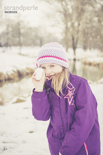 Kleines Mädchen mit Schneeball