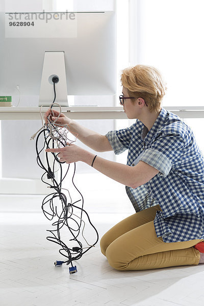 Junge Frau im Büro verbindet Computerbildschirm