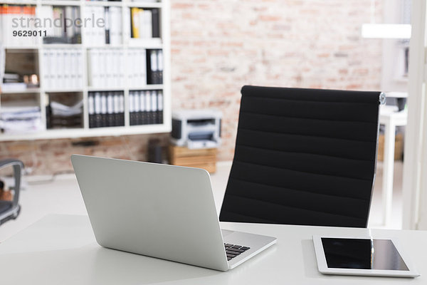 Laptop und digitales Tablett auf dem Schreibtisch im Büro