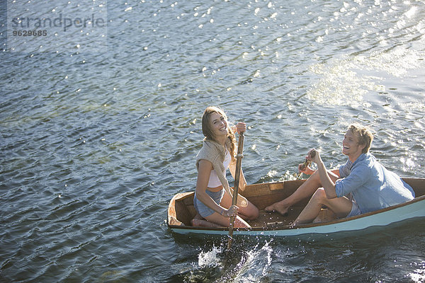 Glückliches junges Paar in einem Ruderboot auf einem See