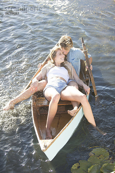 Verspieltes junges Paar in einem Ruderboot auf einem See