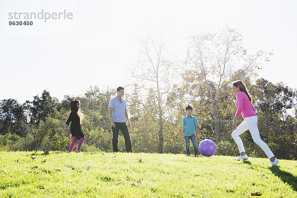 Reife Paare und Kinder beim Fußballspielen im Park