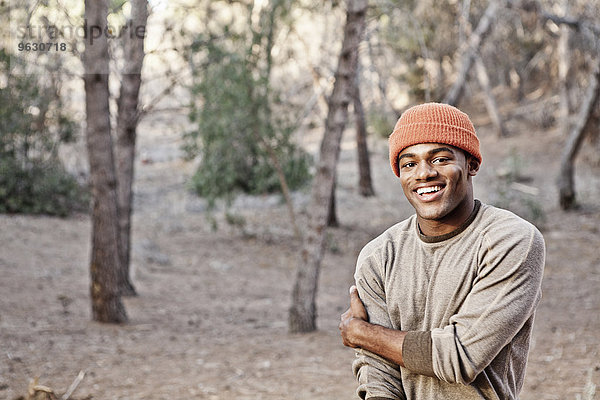 Porträt eines lächelnden jungen Mannes im Wald