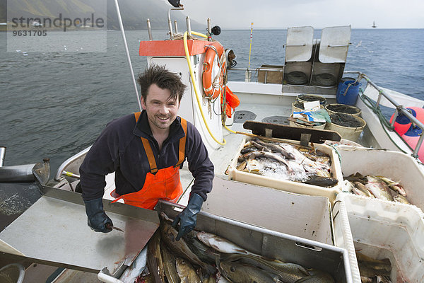 Fischer beim Ausnehmen der Fische auf dem Boot