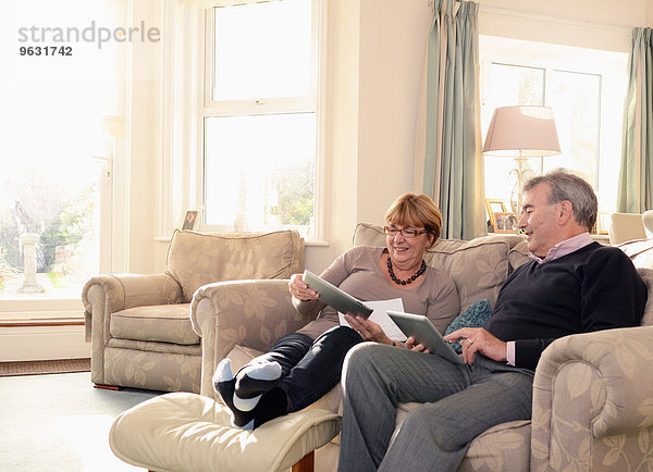 Senior Paar zu Hause auf dem Sofa  Blick auf digitale Tabletten