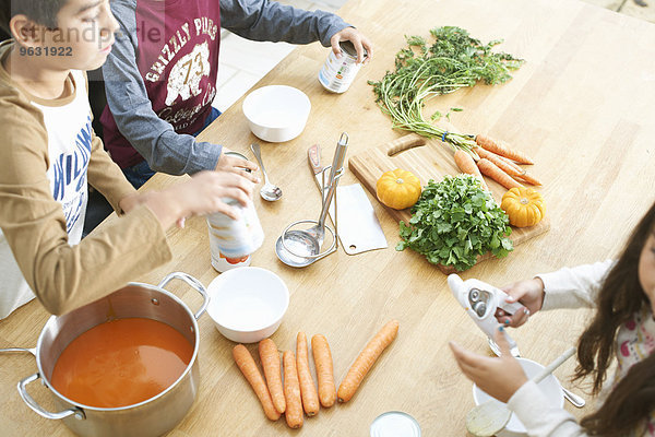 Schnappschuss von Jungen und Schwester beim Öffnen der Tomatensuppe