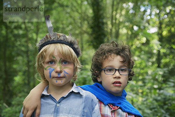 Portrait von zwei Jungen im Wald mit Gesichtsbemalung