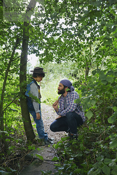 Vater berät Sohn im Wald