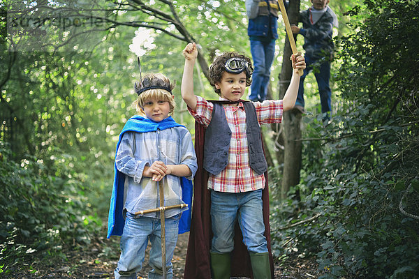 Zwei Jungen  verkleidet und spielend im Wald.