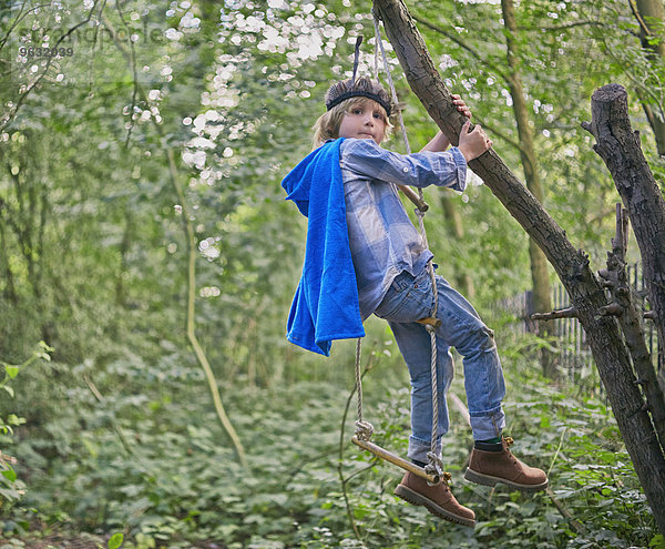 Junge verkleidet und spielend im Waldbaum