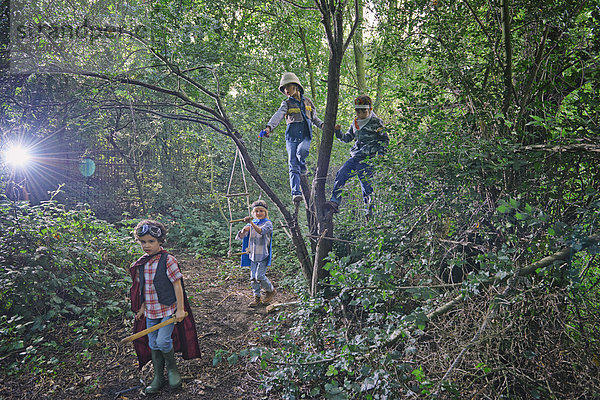 Vier Jungen verkleidet und in Waldbäumen spielend