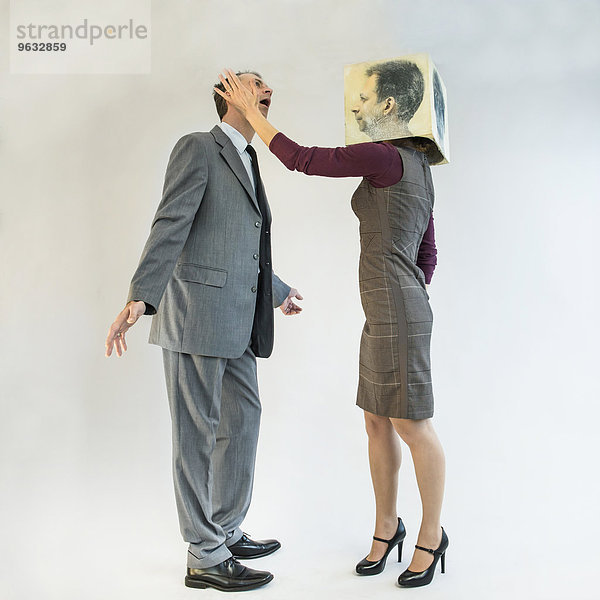 Businessman getting slapped by businesswoman wearing mask