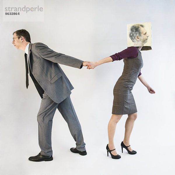 Businessman pulling businesswoman wearing mask