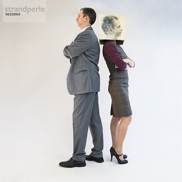 Businessman standing back to back of businesswoman wearing mask