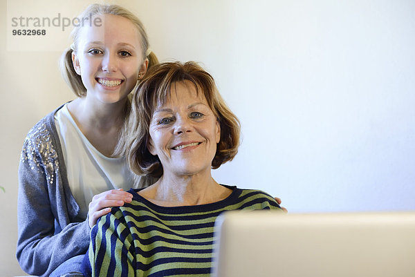 Grandmother and granddaughter with laptop  smiling  portrait