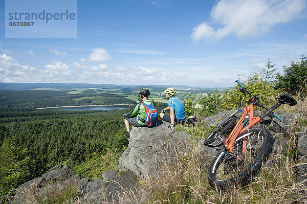 Mountain bikers relaxing on top of mountain  Ore Mountains