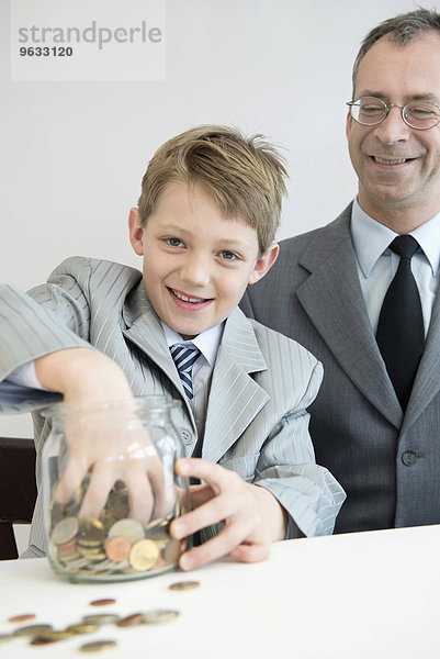 Father and son with piggy bank  smiling