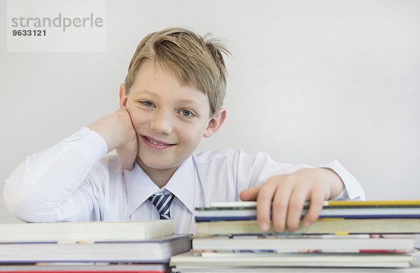 Portrait of boy with stack of books  smiling