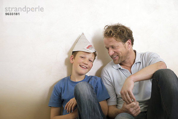 Fun happy father son room floor sitting hat