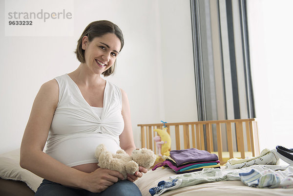 Portrait Pregnant woman holding teddy bear