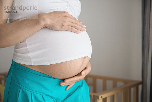 Detail pregnant woman holding stomach close-up
