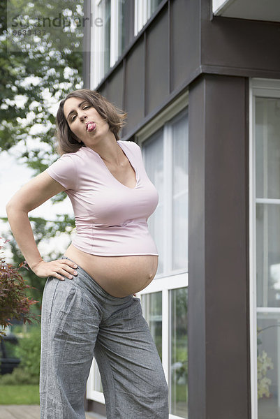 Sticking tongue out cool pregnant woman posing