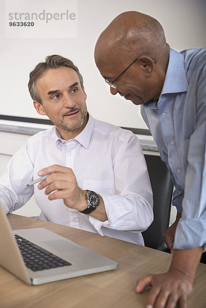 Cooperation two businessmen office computer