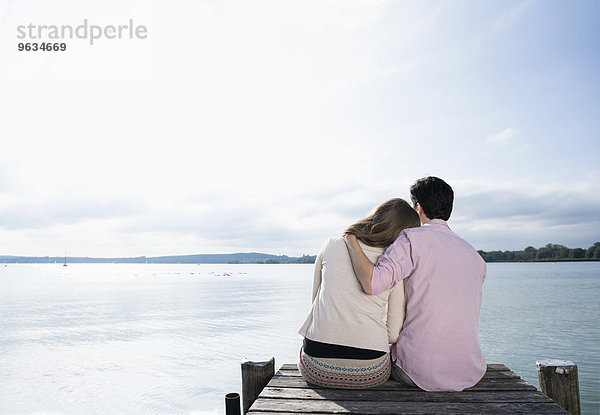 Romantic couple hugging lake jetty tranquil