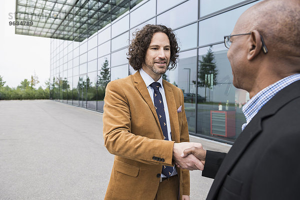 Businessmen two shaking hands meeting multiracial