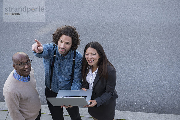 Man pointing explaining laptop work colleagues