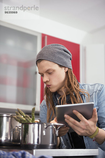Young man looking at recipe on digital tablet
