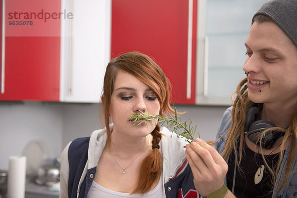 Woman smelling a twig of rosemary