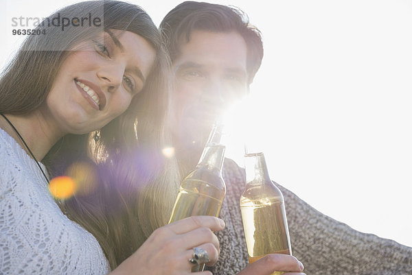 Portrait young couple sunset drinking beer