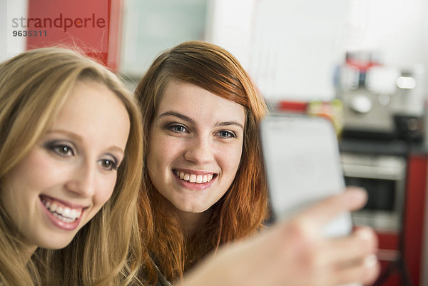 Happy girl friends taking a selfie with smartphone