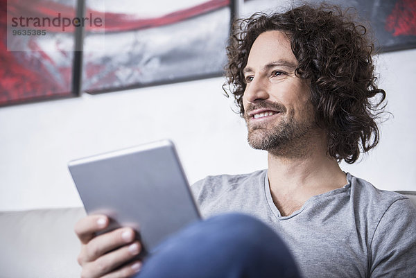 Man using a digital tablet at home