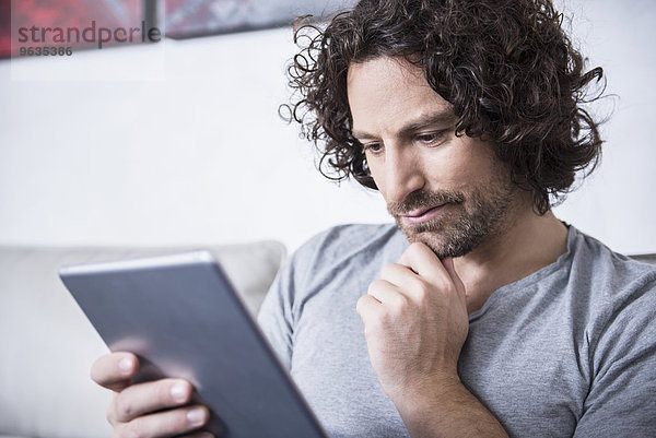 Man using a digital tablet at home