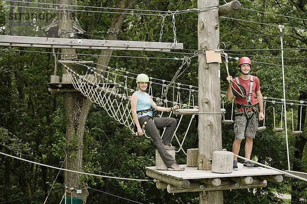 Young man and young woman climbing crag