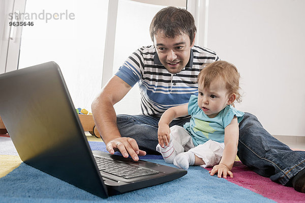 Father baby girl daughter playing laptop
