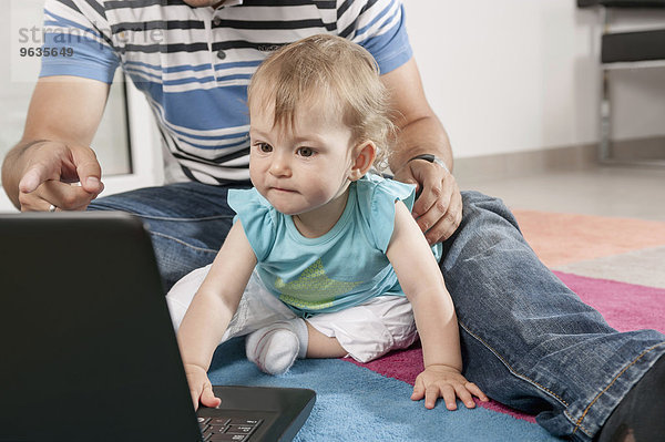Baby concentrating playing computer laptop
