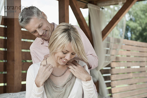 Couple happy woman putting on necklace