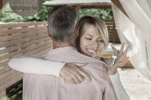 Couple married hugging woman holding keys smiling