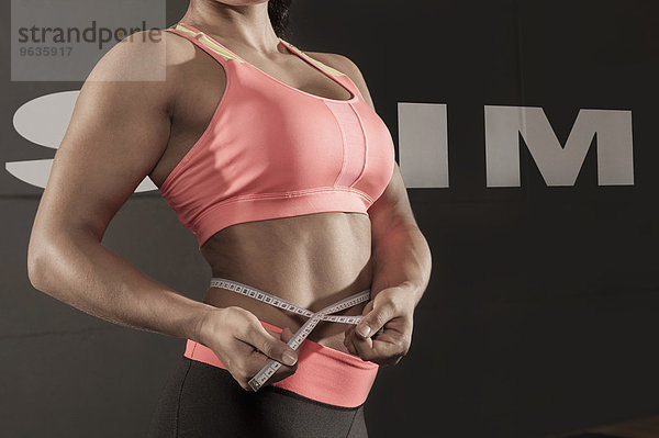 Close up detail muscular woman measuring waist